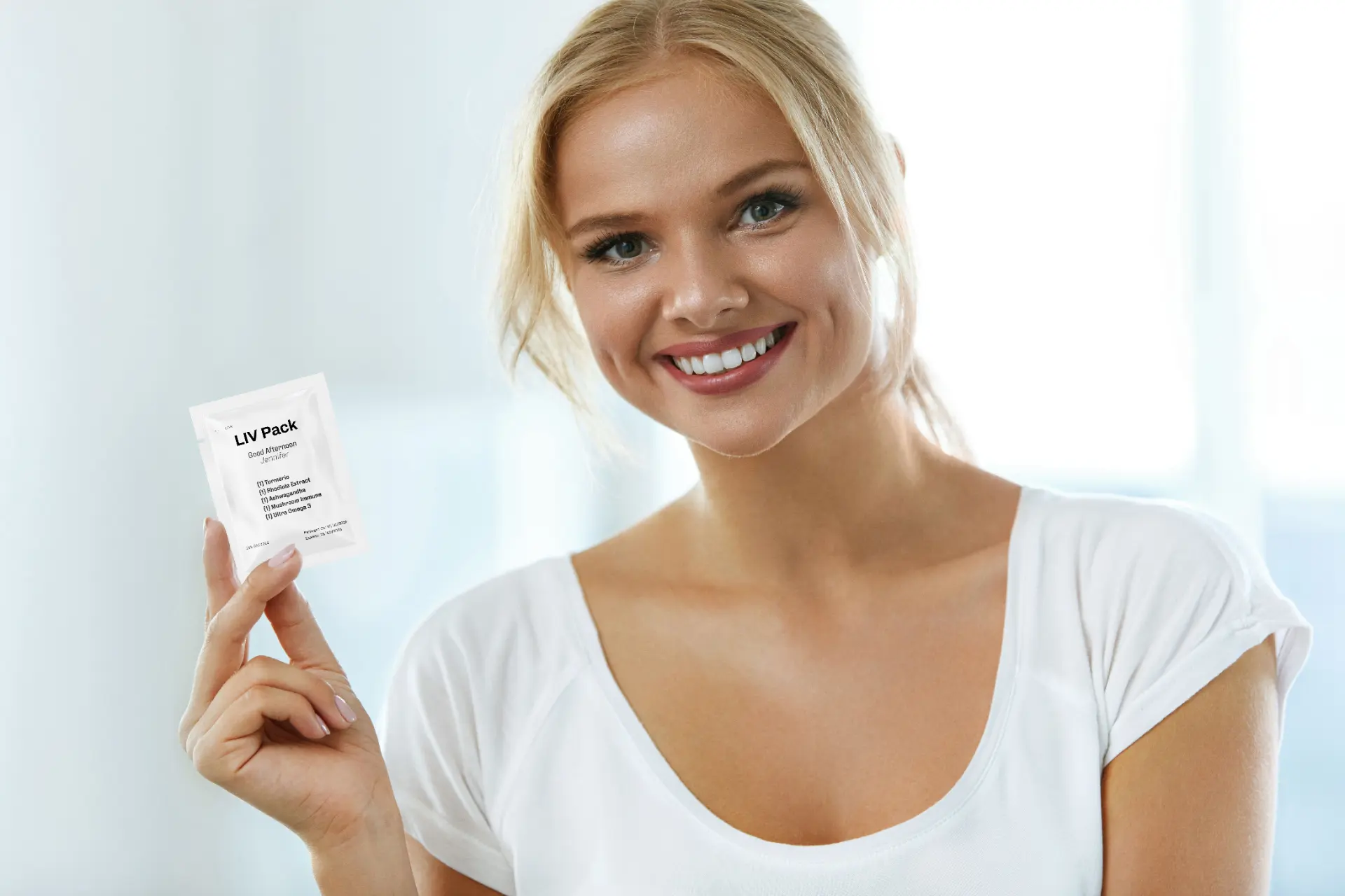 Woman holding a personalized LIV Pack supplement sachet